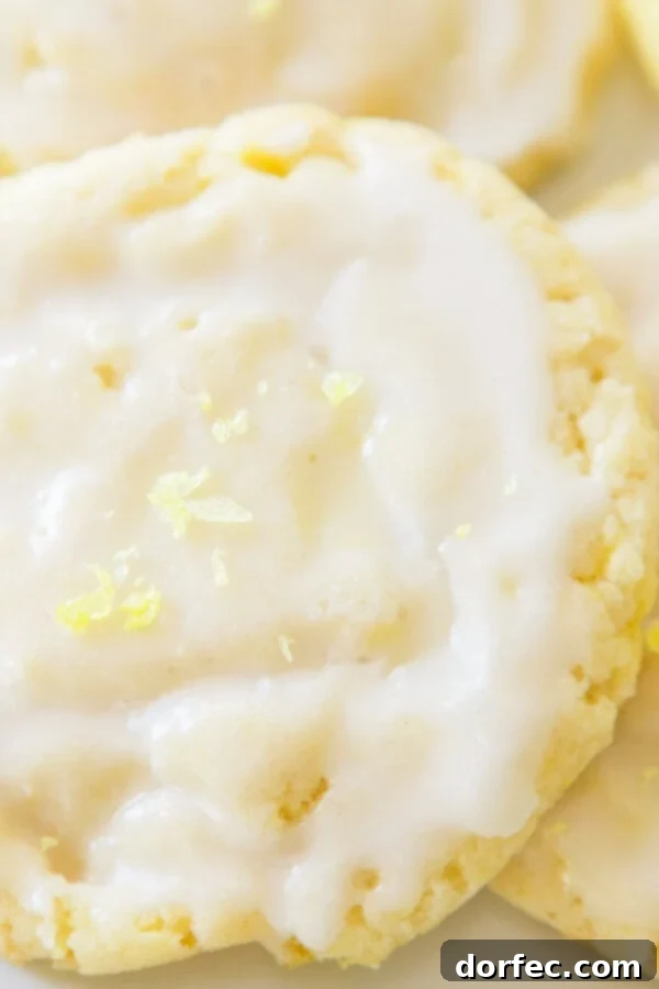 A plate of freshly baked lemon drop cookies, glistening with glaze. ohsweetbasil.com