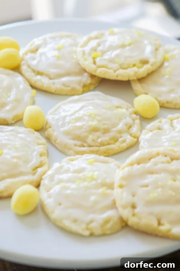 A hand drizzling lemon glaze over a soft lemon drop cookie. ohsweetbasil.com