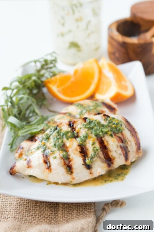 Perfectly grilled orange tarragon chicken breasts, glistening with marinade, ready to be served for a light, flavorful dinner.