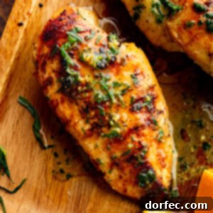 Grilled chicken breast on a wooden cutting board, topped with chopped fresh tarragon and a glossy citrus marinade.