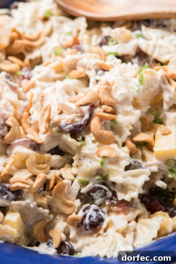 Close-up of creamy Bowtie Chicken Pasta Salad with vibrant pineapple and grapes