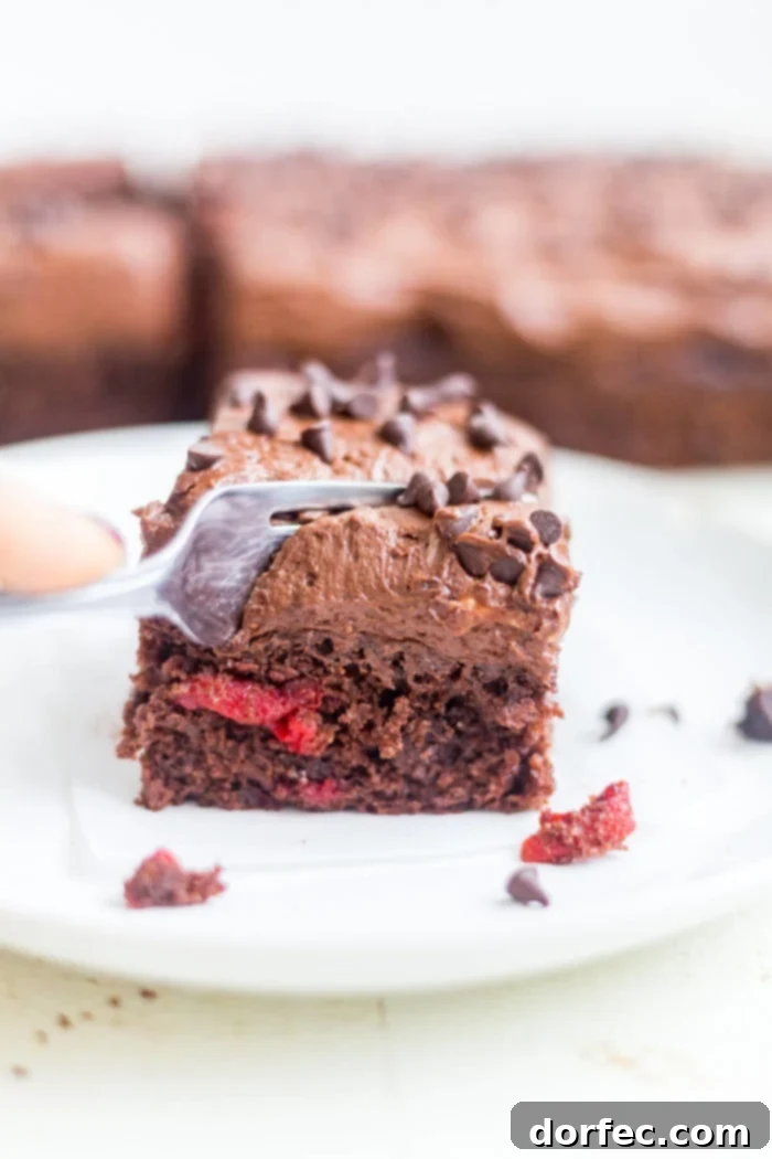 Decadent Chocolate Cherry Cake 3 fork sliding into piece of chocolate cherry cake on plate