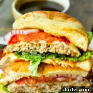 A photo of a pineapple jalapeno turkey burger that has been sliced in half so you can see the inside of the burger, highlighting the juicy patty and colorful toppings.