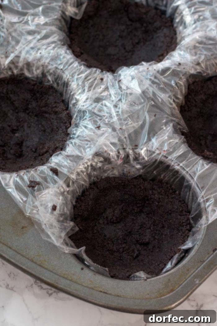 Step-by-step guide to making the perfect crunchy Oreo crust for no-bake mini peanut butter cheesecakes.