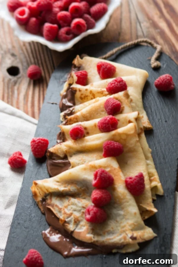 Nutella Crepes French breakfast, hazelnut, raspberry Nutella Crepes served with fresh fruit and powdered sugar, ideal for a French breakfast or dessert