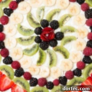 Fruit pizza with a soft sugar cookie crust and creamy cream cheese frosting topped with fresh fruit.