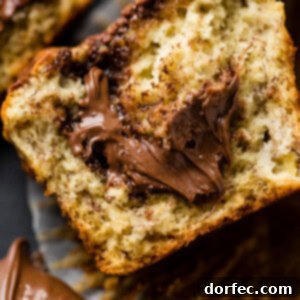 A soft banana muffin cut in half with a dollop of nutella spilling out of the center