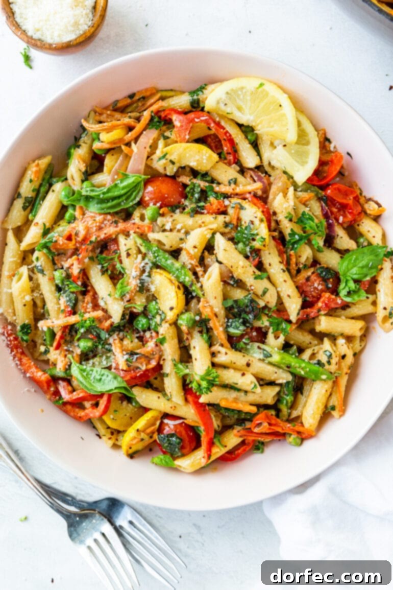 Vibrant Spring Pasta Primavera Recipe 7 A photo of a generous white serving bowl filled with perfectly cooked penne pasta and an inviting mix of fresh, sautéed vegetables, ready to be enjoyed.