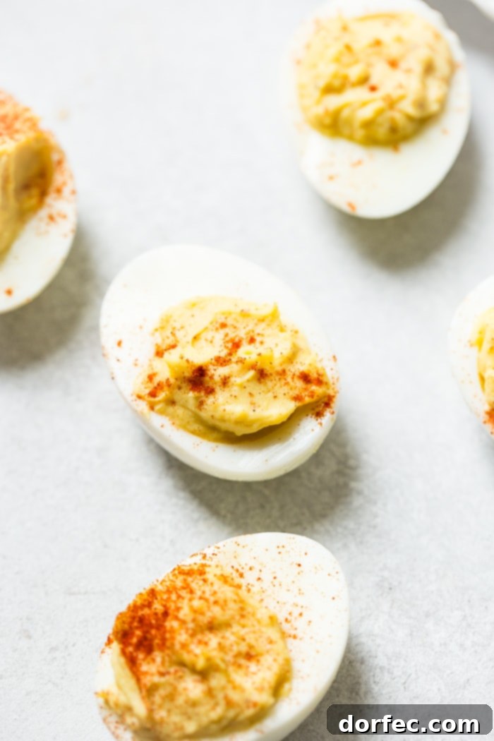 The Ultimate Creamy Deviled Eggs 5 A grey board with deviled eggs with paprika sprinkled on the top which makes the best deviled eggs ever!