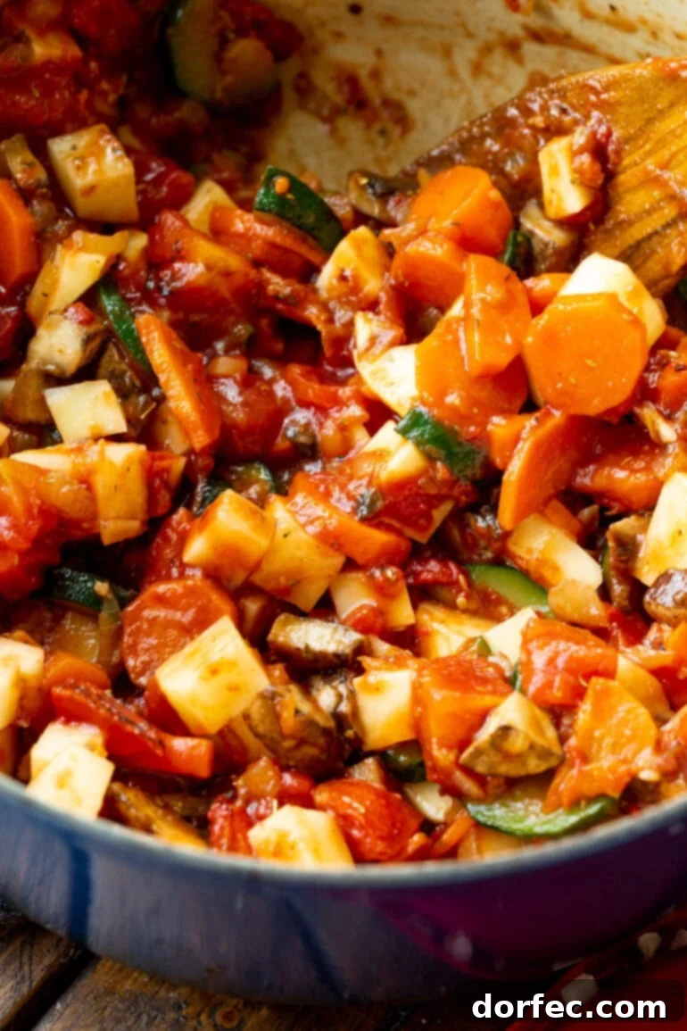 a photo of all the veggies for ham and vegetable soup simmering in a dutch oven pan