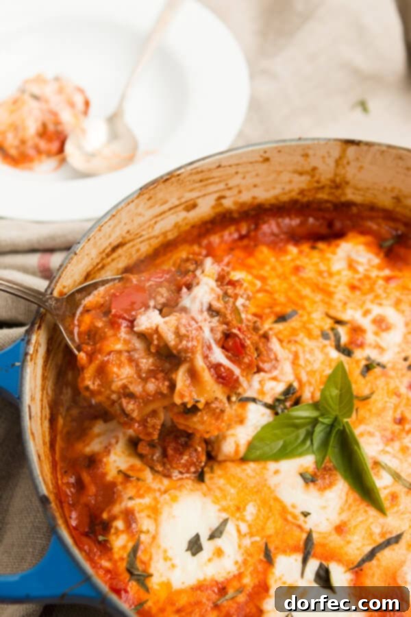 One pot lasagna pasta served directly from the pan, full of melted cheese, rich tomato sauce, and wide noodles, perfect for sharing.