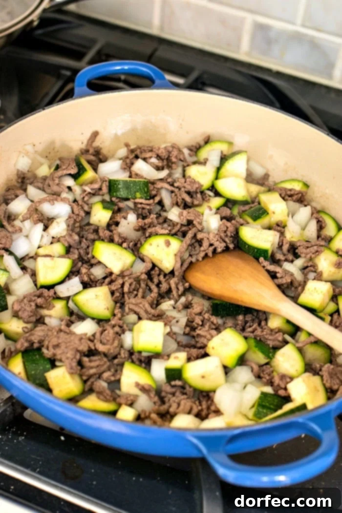 Ground beef browning in a large sauté pan, forming a delicious, savory base for the ragu.