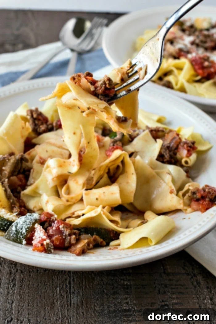 Cooked pappardelle pasta generously coated with rich beef ragu and topped with freshly grated Parmesan cheese.