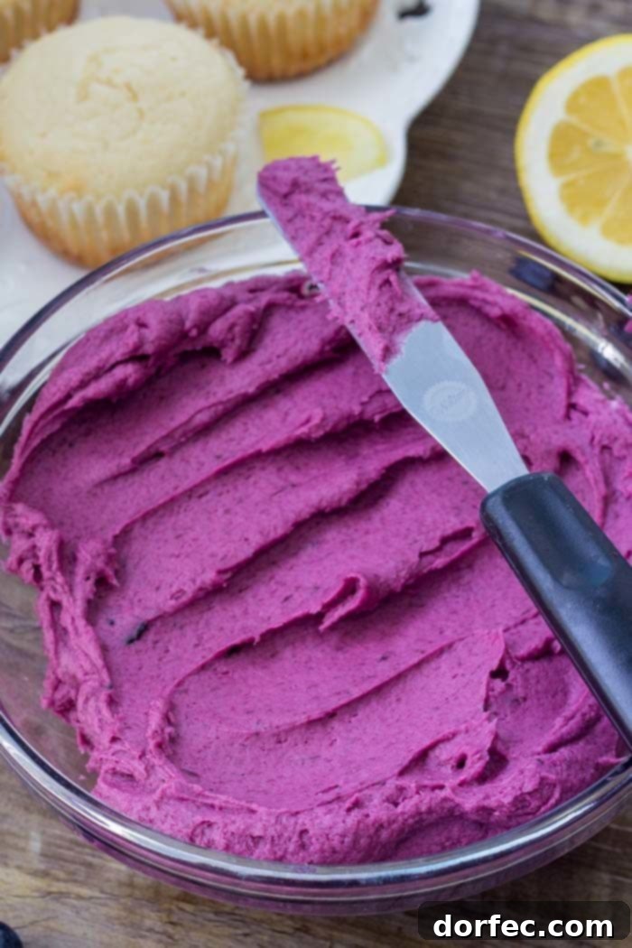 Sunshine Lemon Blueberry Cupcakes 4 A bowl filled with luscious, fluffy blueberry frosting, ready to adorn freshly baked lemon cupcakes.