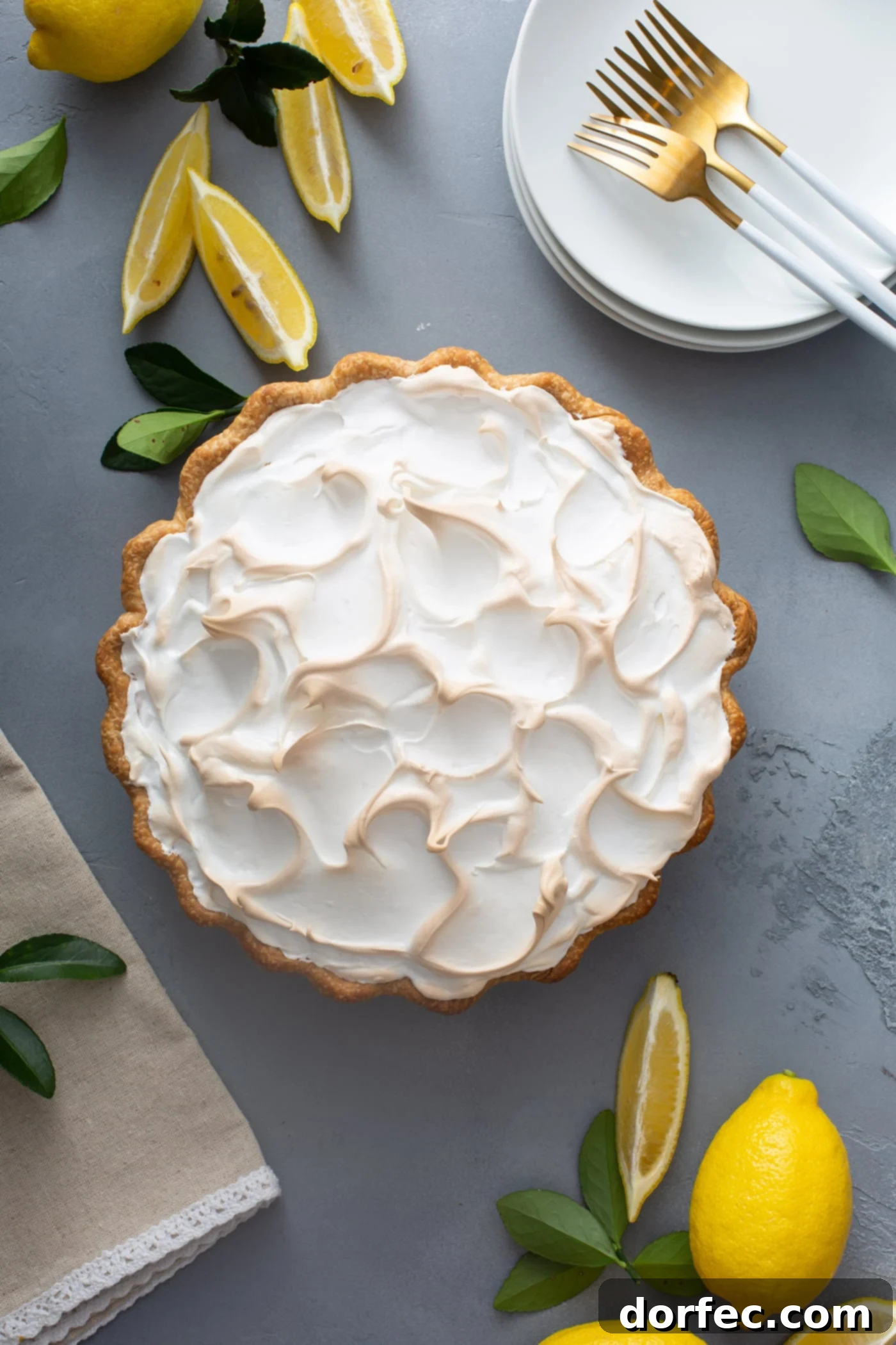 Mom's Lemon Meringue Pie A picture of a lemon meringue pie. the meringue is fluffy and slightly browned. There are lemon wedges next to the pie.