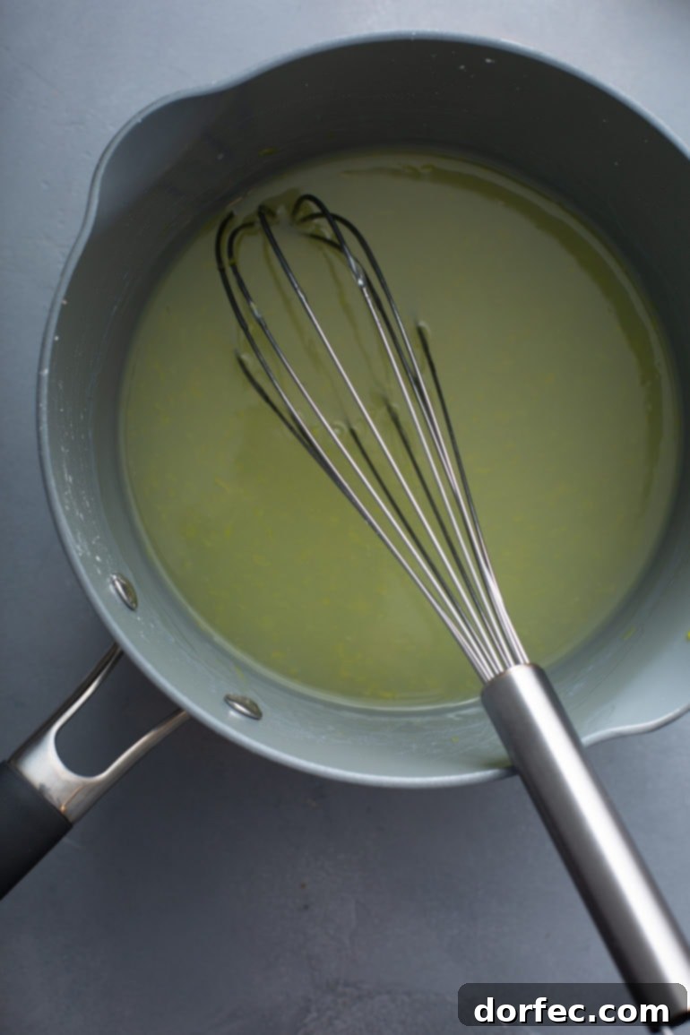 Family Recipe Lemon Meringue Pie 5 A sauce pan with lemon pie filling in it. It has a whisk resting in the filling.