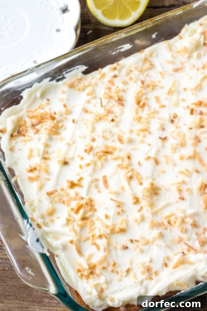 Moist lemon sheet cake generously frosted with luscious coconut buttercream, ready to be served.