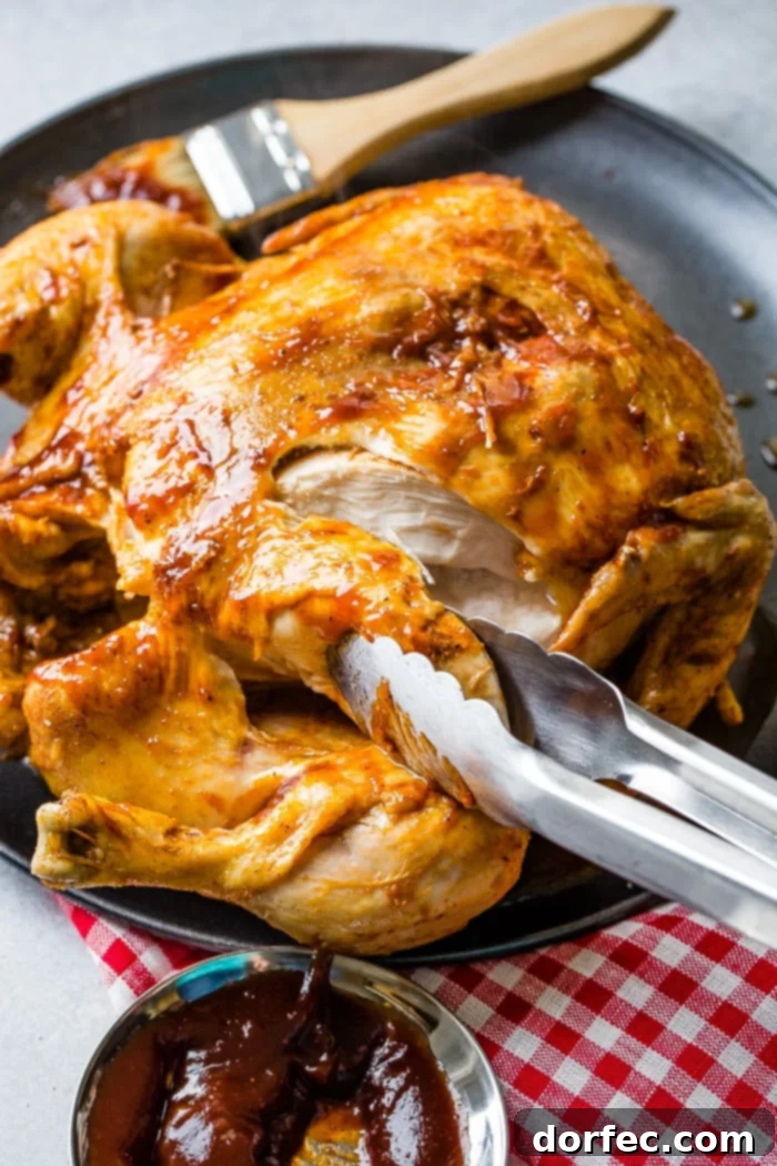 Ultimate Instant Pot BBQ Whole Chicken 2 A red and white checkered napkin under a grey plate with a bbq instant pot whole chicken on top!