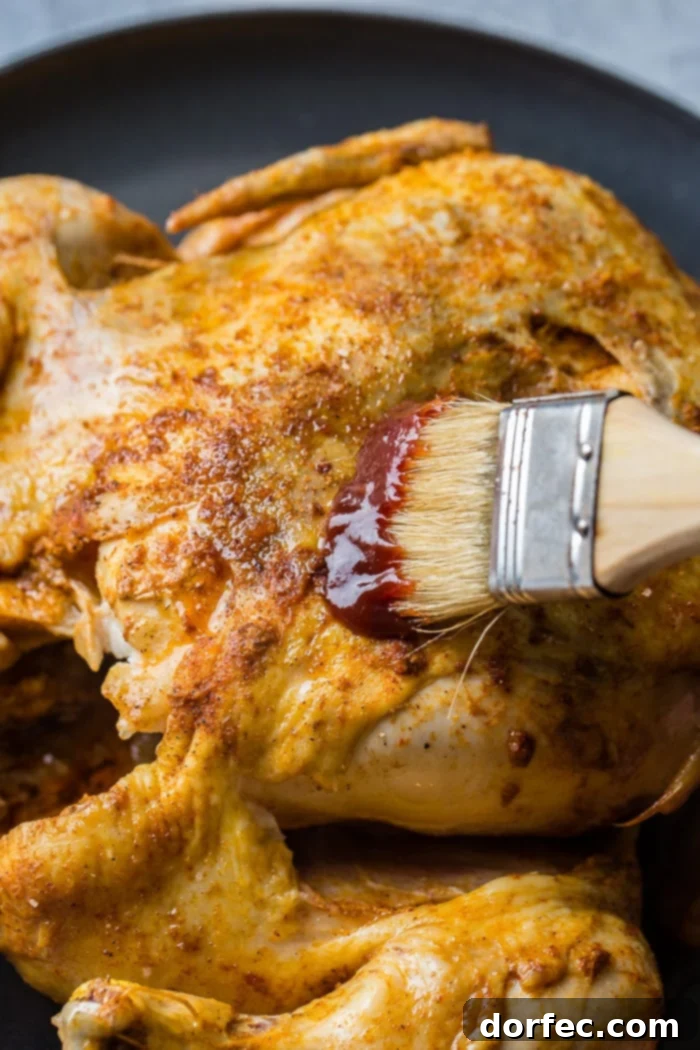 Ultimate Instant Pot BBQ Whole Chicken 4 A red and white checkered napkin under a grey plate with a bbq instant pot whole chicken on top!