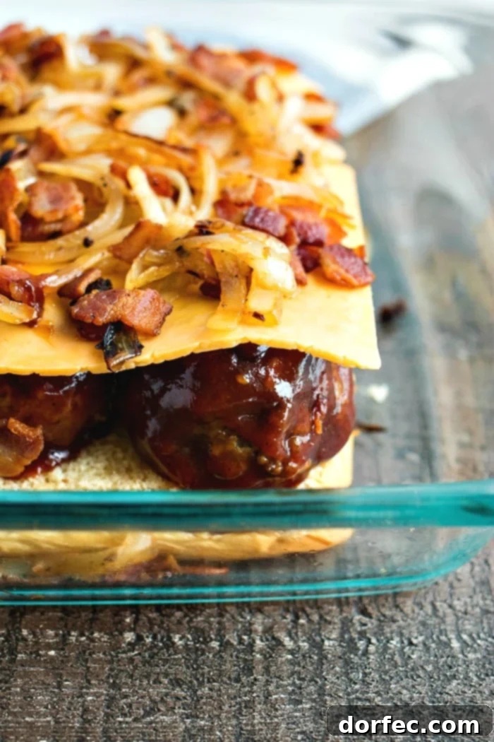 bbq meatball sliders being assembled in baking tray