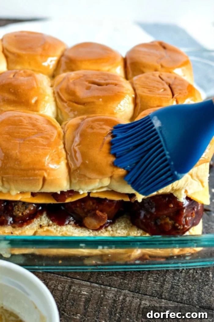 brushing butter mixture onto bbq meatball sliders
