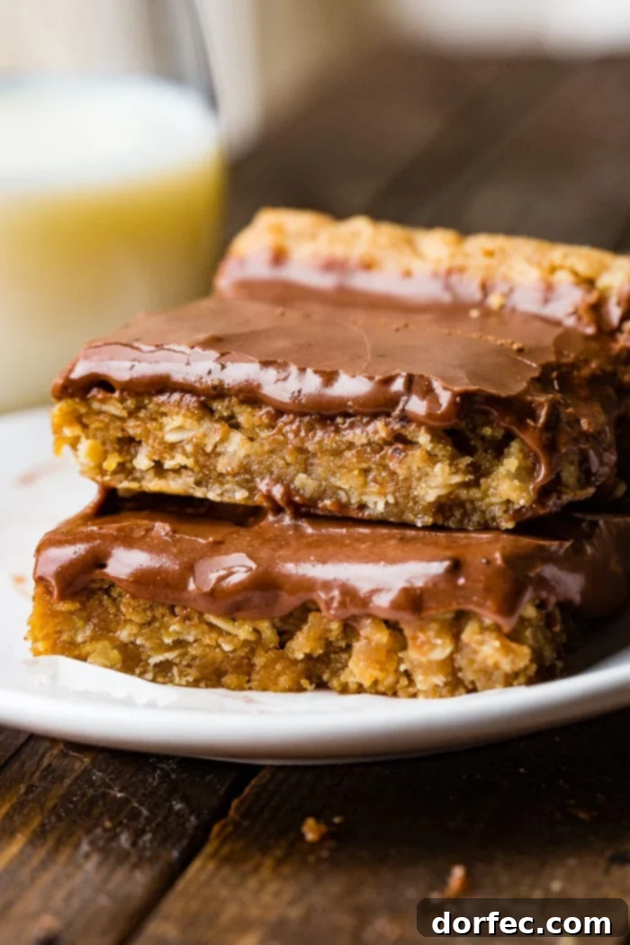 A beautifully presented stack of Chocolate Peanut Butter Bars on a rustic wooden surface.