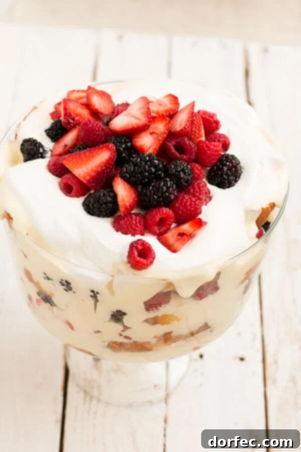 Irresistible Lemon Curd Berry Trifle: A Perfect Summer Dessert A stunning Lemon Curd Berry Trifle, showcasing vibrant layers of yellow curd, mixed berries, and white cake, topped with fresh mint for a refreshing garnish.