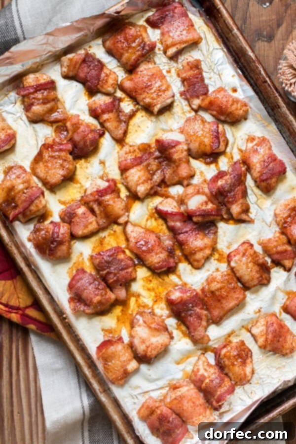 Crispy Brown Sugar Bacon-Wrapped Chicken on a Baking Tray overhead view of baked chicken with bacon on a baking tray, perfectly golden brown and crispy