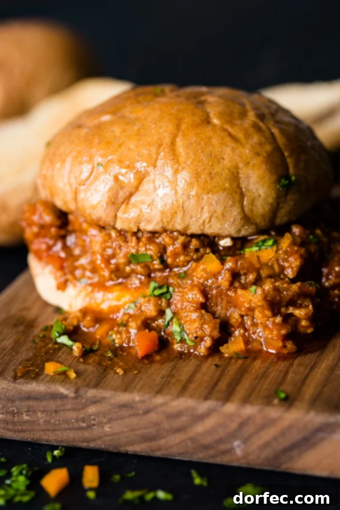 Delicious and healthy ground turkey sloppy joe served on a bun with bread in the background