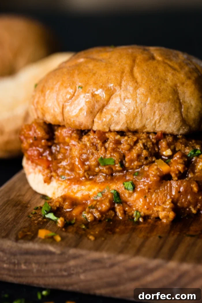 Hearty ground turkey sloppy joe served on a bun, ready to eat on a wooden board
