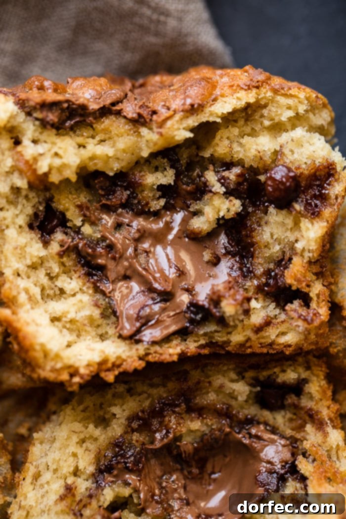 Nutella Surprise Peanut Butter Banana Muffins 2 Peanut butter banana muffins loaded with chocolate chips, peanut butter chips, stuffed with Nutella, and Nutella swirled on top. A truly decadent breakfast or dessert!
