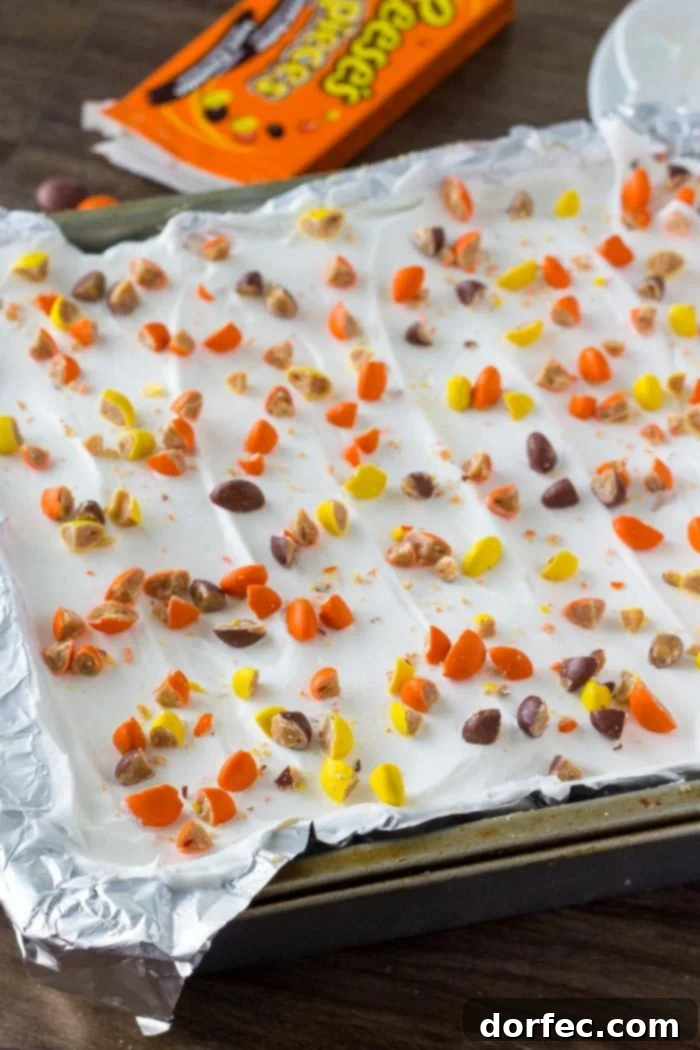 Peanut butter icebox cake topped with whipped topping and peanut butter candies. 