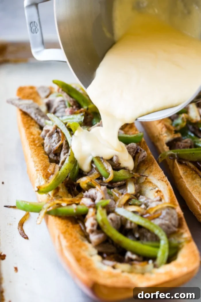 Philly Cheesesteak Stuffed Loaf 2 A freshly baked French bread loaf, sliced open and generously filled with tender steak, sautéed peppers, onions, and smothered in a rich cheese sauce, ready to be served as an easy Philly Cheesesteak recipe.