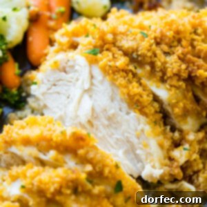 a grey plate full of steamed veggies and golden, baked quick and easy cornflake ranch chicken recipe which has been sliced into pieces of chicken