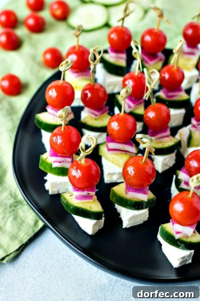Fresh Greek Salad Skewers 5 Assembling Greek Salad Skewers with cherry tomatoes, cucumber, red onion, and feta