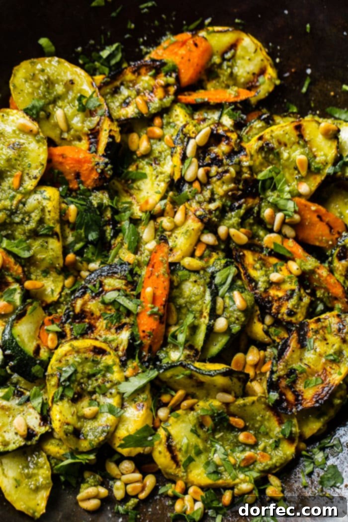 A close-up of beautifully grilled vegetables, featuring a mix of zucchini, yellow squash, and carrots, expertly seasoned and ready for the pesto drizzle. This image emphasizes the ease and deliciousness of the 15-minute grilled veggies with pesto recipe.