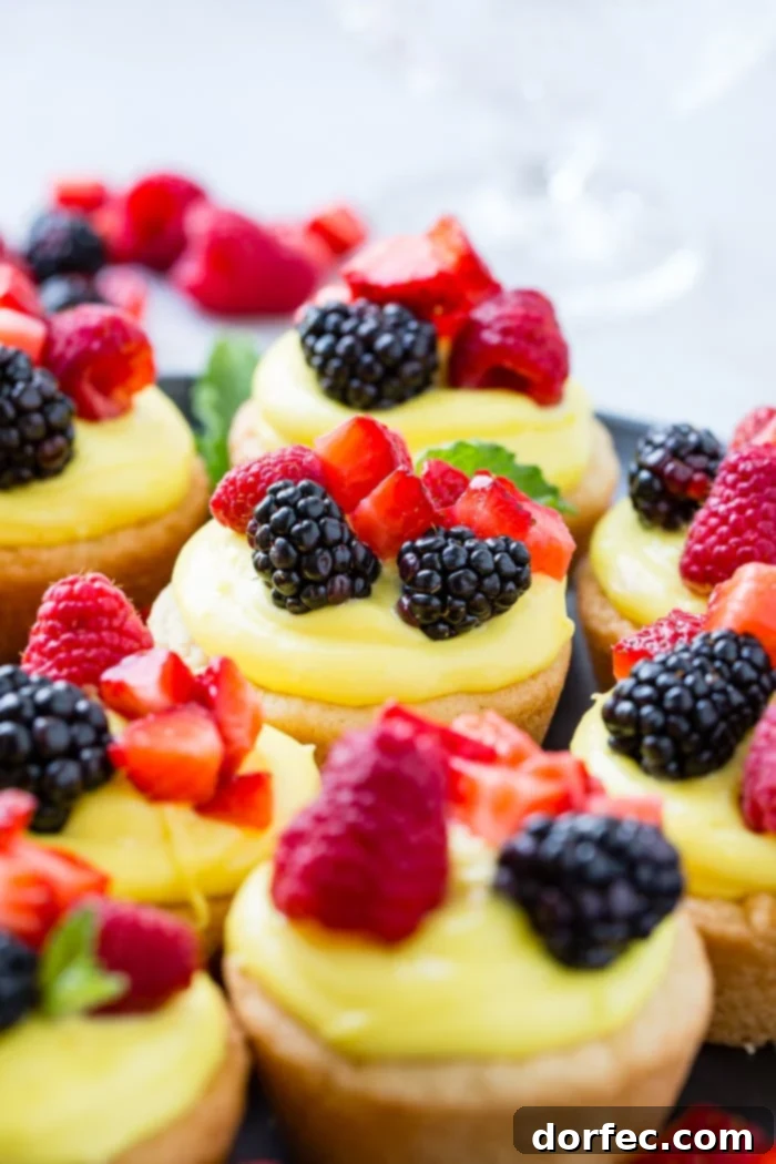 Sunshine Lemon Sugar Cookie Bites 6 A dark pan filled with golden-baked sugar cookie cups, each perfectly shaped and ready to be filled with the lemon cream and fresh berries. This image highlights the crisp edges and soft centers of the cookie cups.