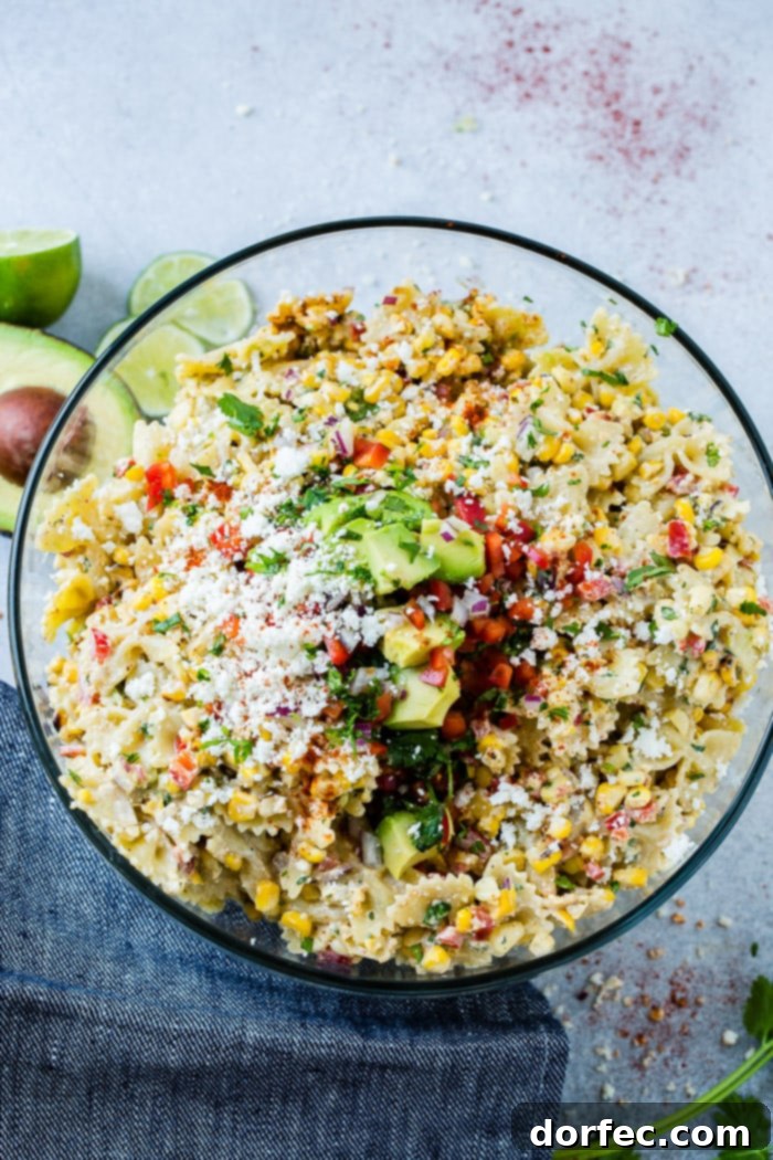 photo of a bow tie pasta salad with avocados, peppers, grilled corn, cilantro, and cotija cheese making up an Elote Mexican Corn Pasta Salad