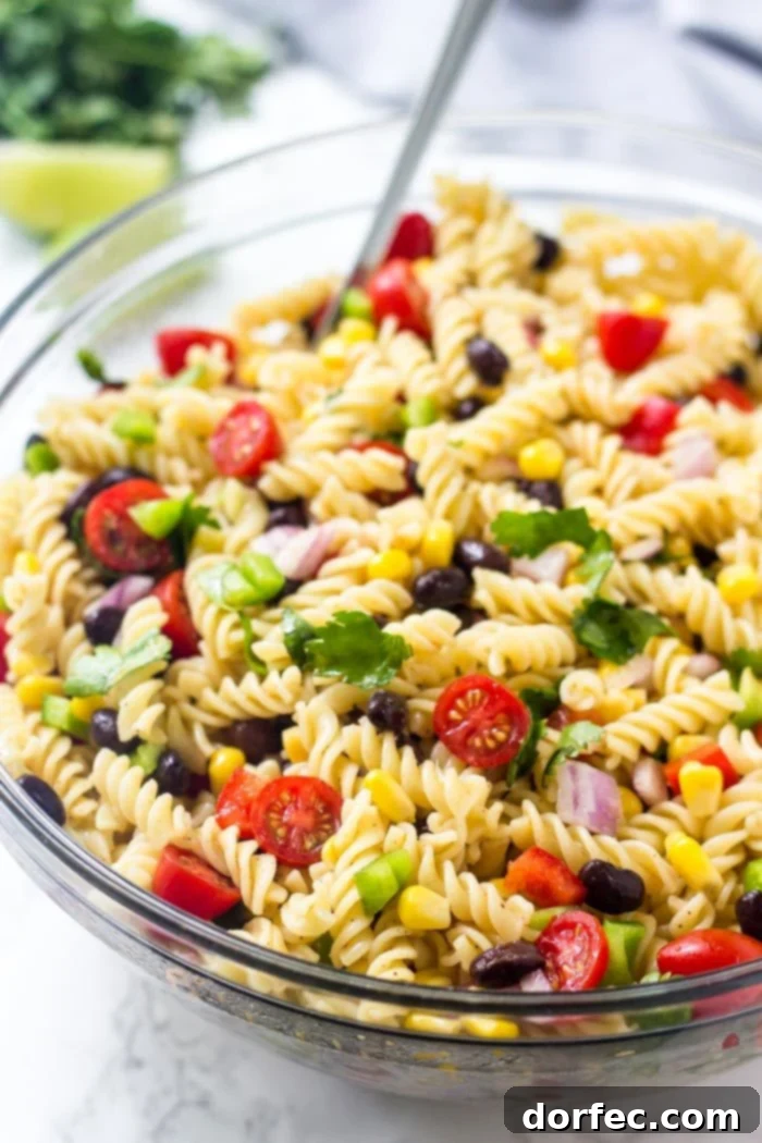 Zesty Tex-Mex Pasta Salad 2 A bowl of southwest pasta salad brimming with colorful corn, tomatoes, black beans, and fresh cilantro, perfect for outdoor events.