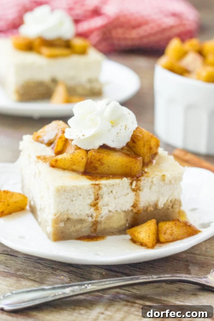 Caramel Apple Cheesecake Bars 2 A slice of apple cheesecake bars topped with cinnamon sugar apples and whipped cream