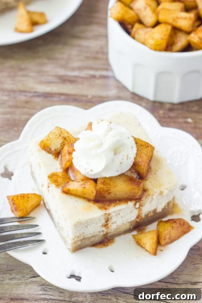 Caramel Apple Cheesecake Bars 3 A slice of apple cheesecake bars topped with cinnamon sugar apples and whipped cream
