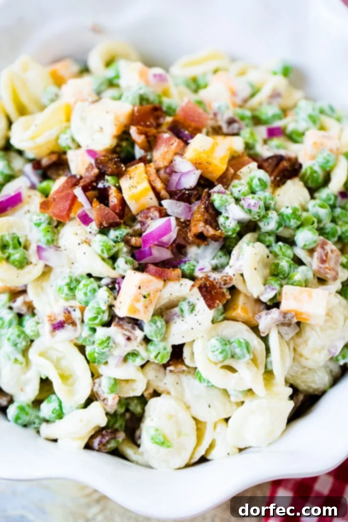 Close-up shot of homemade Southern English Pea Pasta Salad, showcasing the delicious blend of orchiette pasta, vibrant peas, and cheese cubes.