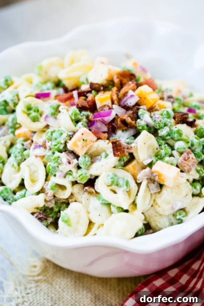 Detailed shot of the creamy dressing coating the orchiette pasta, English peas, and Colby Jack cheese in a Southern Pea Pasta Salad.