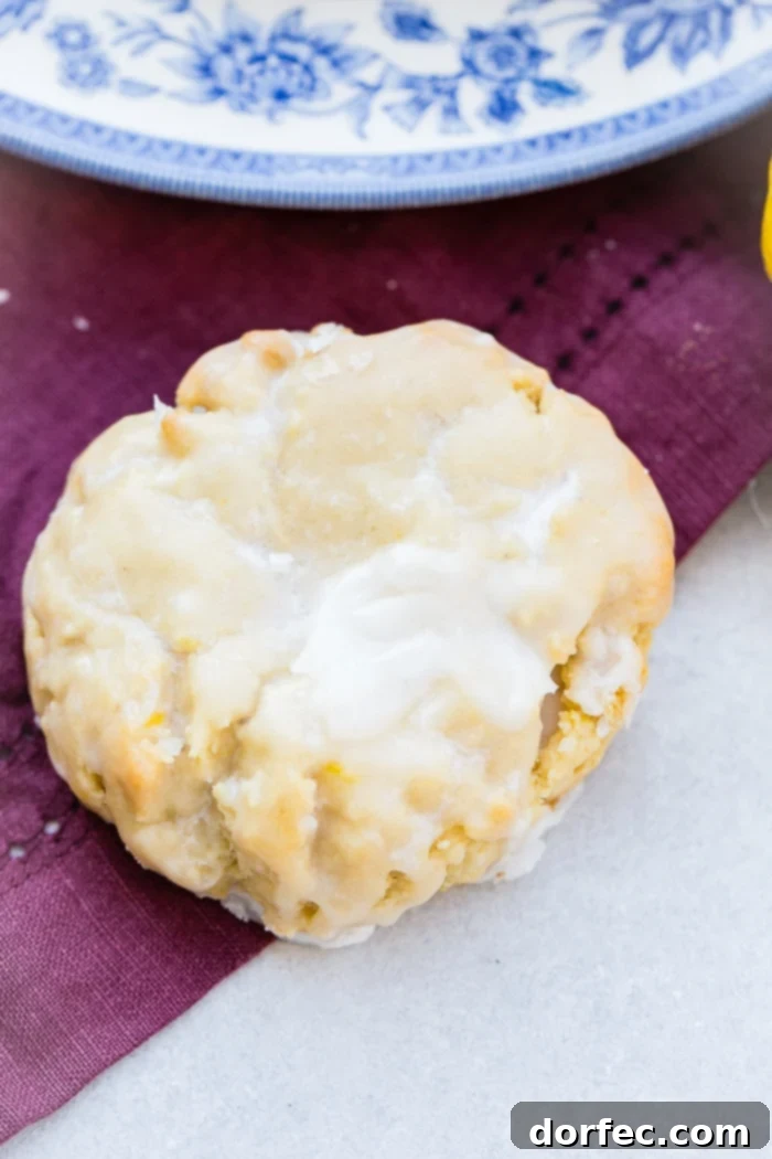 a pile of glazed lemon cookies on a blue floral vintage plate with slices of lemon