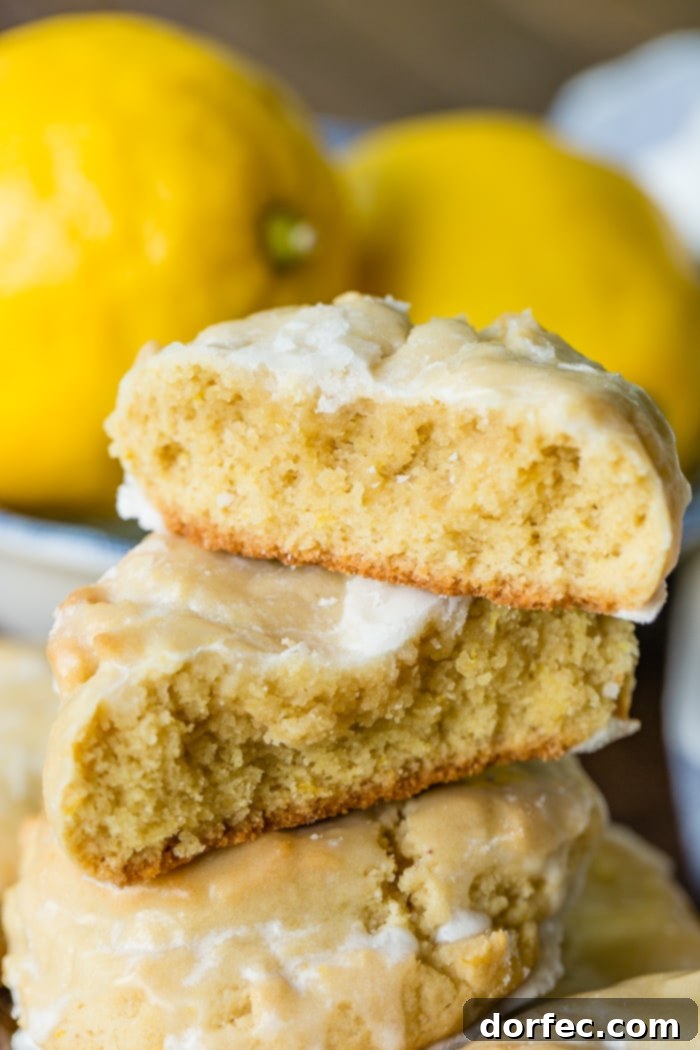a pile of glazed lemon cookies on a blue floral vintage plate with slices of lemon