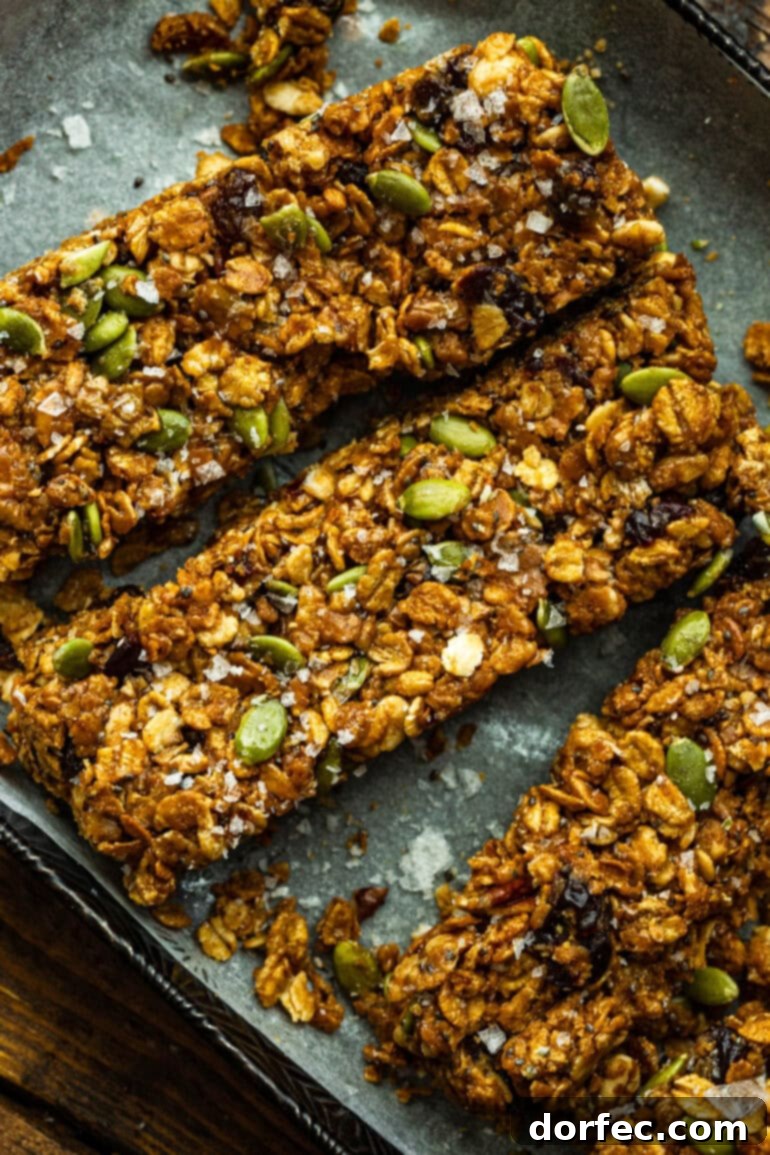 Homemade Cereal Bars 3 Chewy peanut butter cereal bars artfully arranged on a pristine white parchment paper, highlighting their delicious texture and wholesome ingredients.