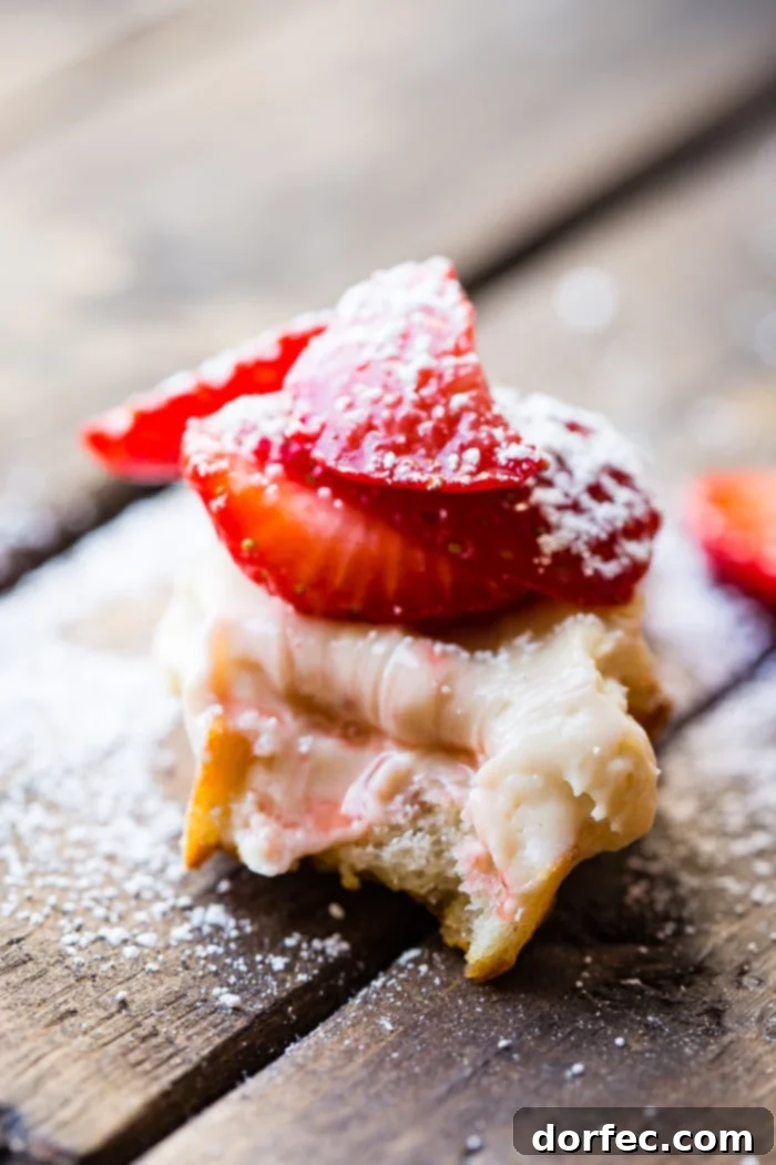 Golden Brown Sugar Strawberry Crostini 3 A rustic brown wooden board showcasing multiple Brown Sugar Strawberry Crostinis, some dusted lightly with powdered sugar.