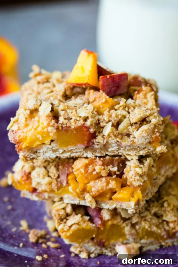 A dark purple plate with a stack of healthy peach oatmeal bars, glazed, highlighting the appealing texture and fresh ingredients.