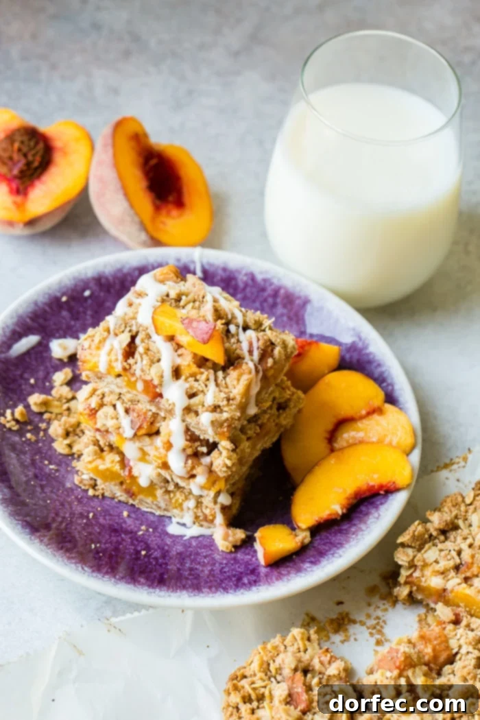 A dark purple plate with a stack of healthy peach oatmeal bars, glazed, showing off their rustic appeal and wholesome texture.