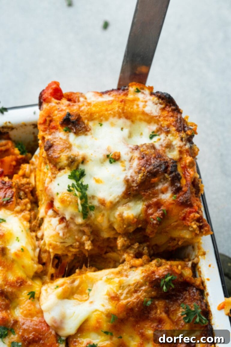 a photo of a serving of meaty lasagna being removed from the corner of a baking dish